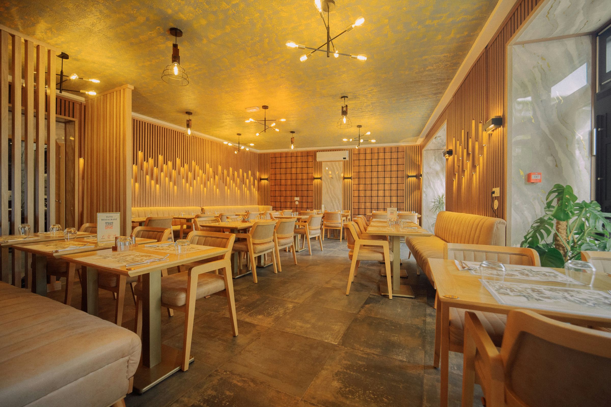 Restaurant lounge with warm gold ceiling and banquette seating